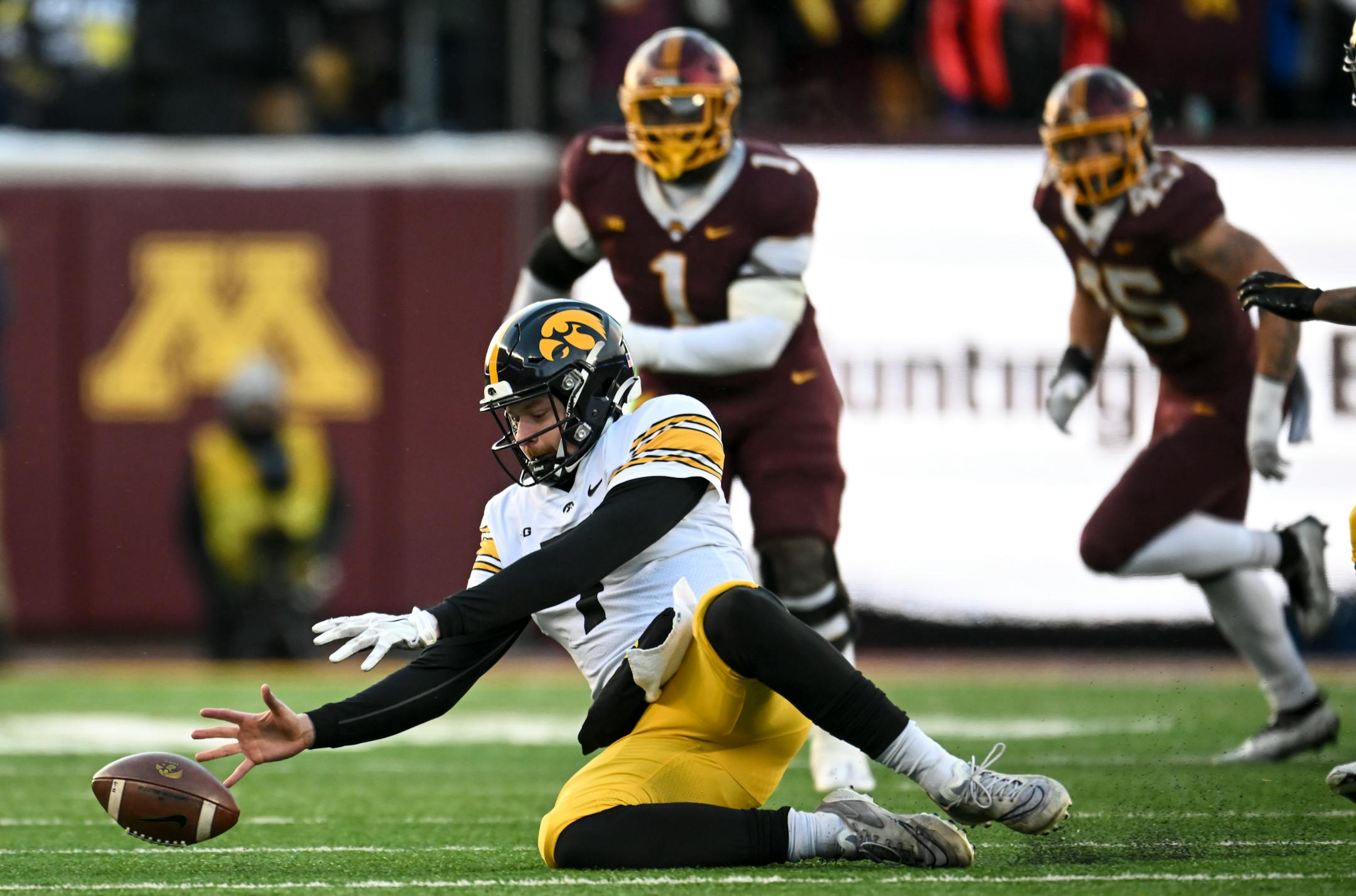 Iowa Hawkeyes quarterback Spencer Petras (7) chases down the ball after a botches snap during the first half of an NCAA football game against the Minnesota Gophers.