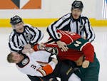 Referees Don Henderson, left, and Mike Cvik break up a fight between Anaheim Ducks� Clayton Stoner, left, and Minnesota Wild�s Chris Stewart in th