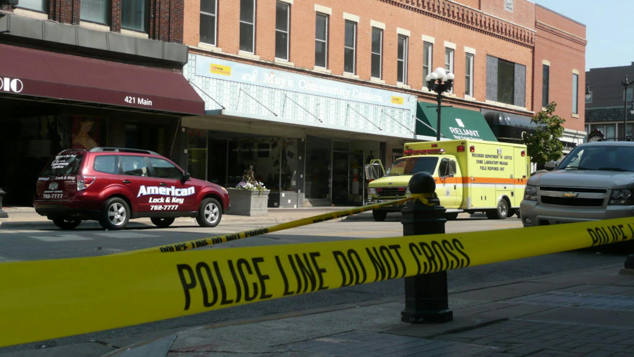 Main Street is closed to traffic Sunday between Fourth Street and Fifth Avenue in La Crosse, Wis., as local and state police investigate the killings of Paul Petras and his son, A.J. Petras.