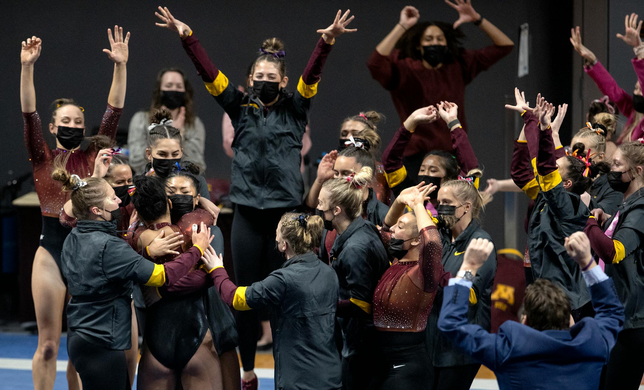 Mya Hooten of Minnesota is greeted by teammates after competing in the floor exercise.