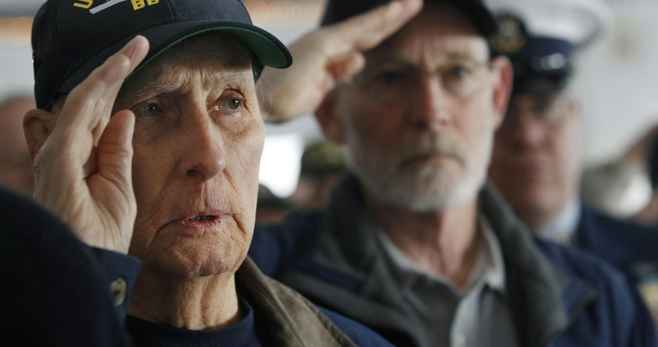 World War II veteran and original crew member of the battleship New Jersey, Russell Collins, left, salutes with others on the battleship during a commemoration of the 74th anniversary of the attack on Pearl Harbor, Monday, Dec. 7, 2015, in Camden, N.J. In Pearl Harbor, the U.S. Navy and National Park Service hosted a ceremony in remembrance of those killed on Dec. 7, 1941. (AP Photo/Mel Evans)