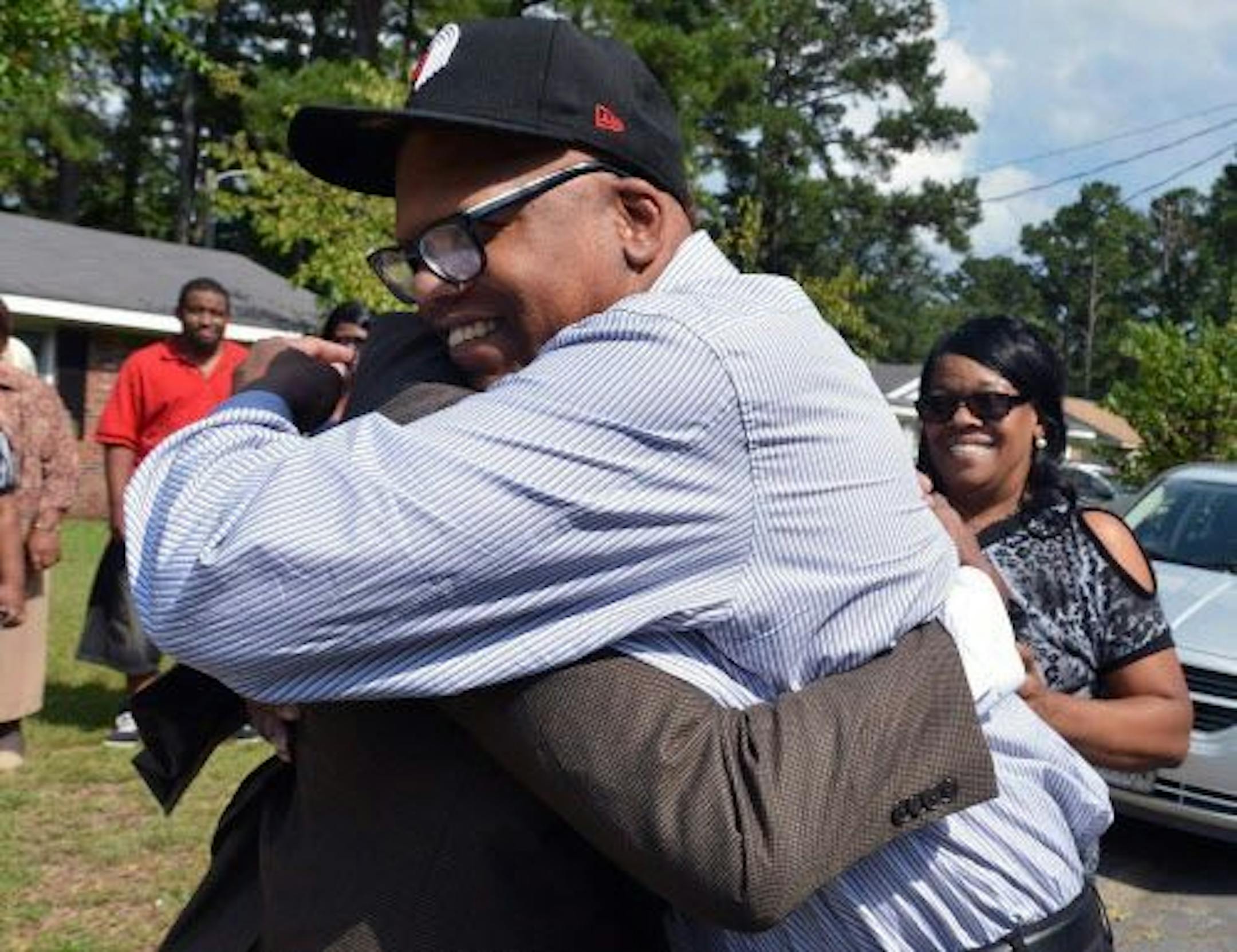 Half brothers Leon Brown, right, and Henry McCollum greet each other in the front yard of a Fayetteville, N.C. home Wednsday, Sept. 3, 2014. The brothers were released from prison Wednesday after their rape and murder conviction was dismissed.