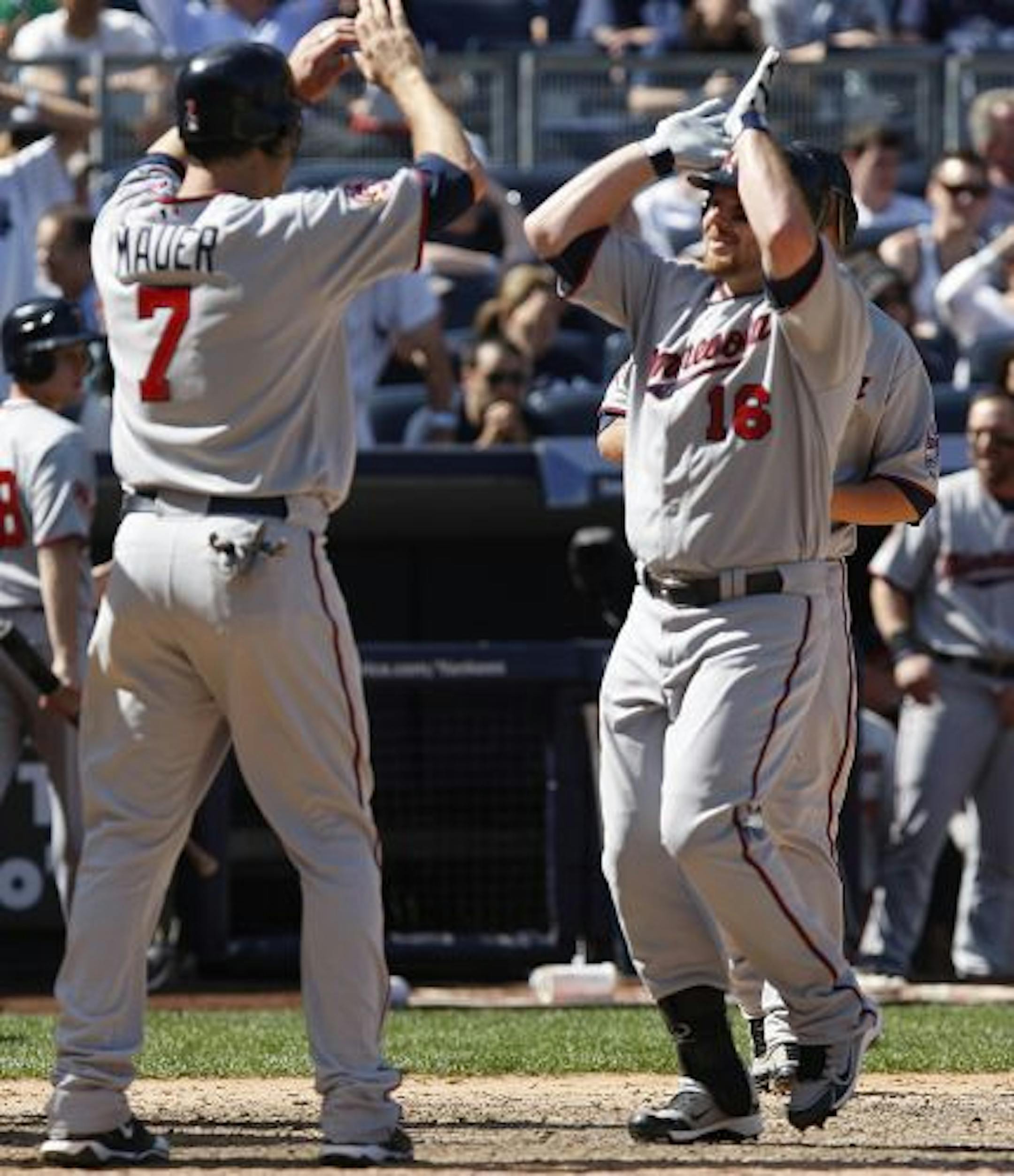 Jason Kubel, right, is greeted by teammate Joe Mauer after hitting a grand slam during the eighth inning against the New York Yankees.