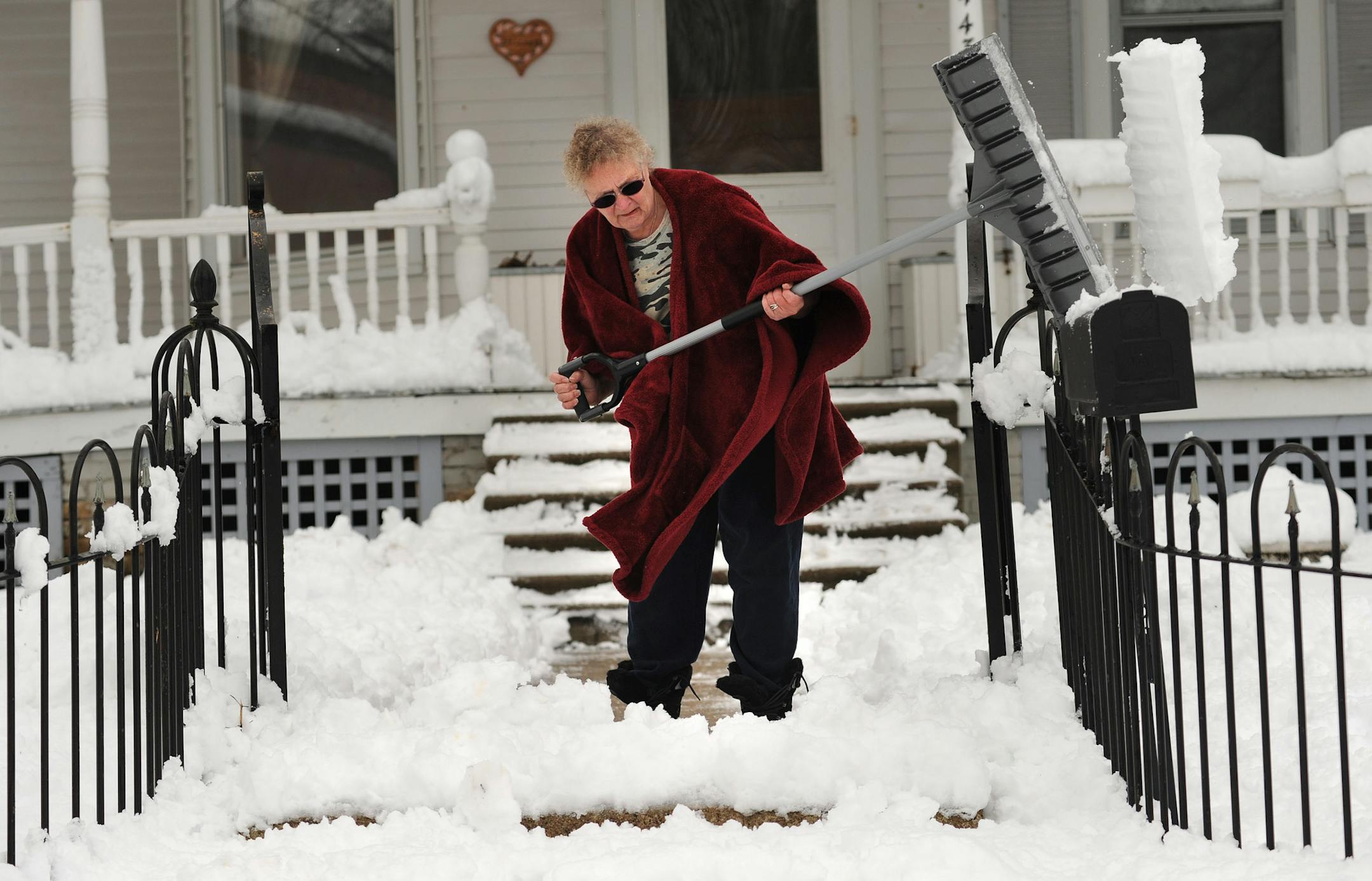 A very late spring storm dumped almost a foot of snow on Owattana area over night causing power outages, school closings and downing many tree limbs. Jeannie Kaupins cleared the snow from her sidewalk in front of her house in Owatana ] Richard.Sennott@startribune.com Richard Sennott/Star Tribune. , Owatana Minn.Thursday 5/2/13) ** (cq)