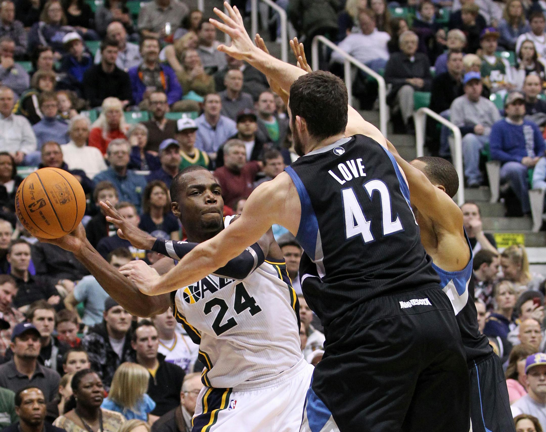 Utah Jazz forward Paul Millsap (24) attempts to pass off the ball as Minnesota Timberwolves forward Kevin Love (42) defends during the second half of an NBA basketball game, Saturday, Jan. 21, 2012, in Salt Lake City. Millsap scored 26-points in the Jazz' 108-98 win. (AP Photo/Colin E Braley)