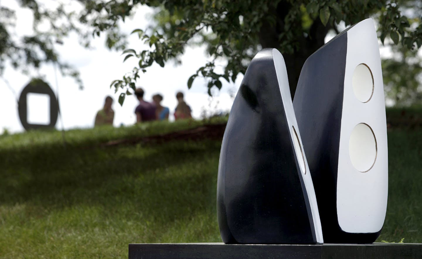 Leslie Johnson (brown shirt) said, "This is where my husband proposed to me. We bring our friends and family to out here to the same spot." With the sculpture "Summer Dance" by Barbara Hepworth, Leslie Johnson, daughter Sophia, son Charlie of St. Louis Park and Emily Johnson (blue shirt), and Anna Johnson from Portsmith, New Hampshire had a picnic under the trees at the scupture garden with "DISC SPIRAL" 2000 by Jesus Bautista Moroles in the background at the University of Minnesota Landscape Ar