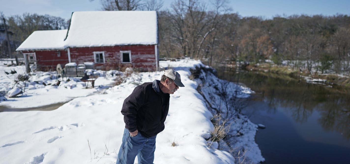 Retired conservationist Tom Kalahar inspected the banks of Hawk Creek, which he said is an example of what can happen when waterways are mismanaged. The Korstads' hobby farm teeters on the edge of the harshly eroded banks; a row of walnut trees fell in.