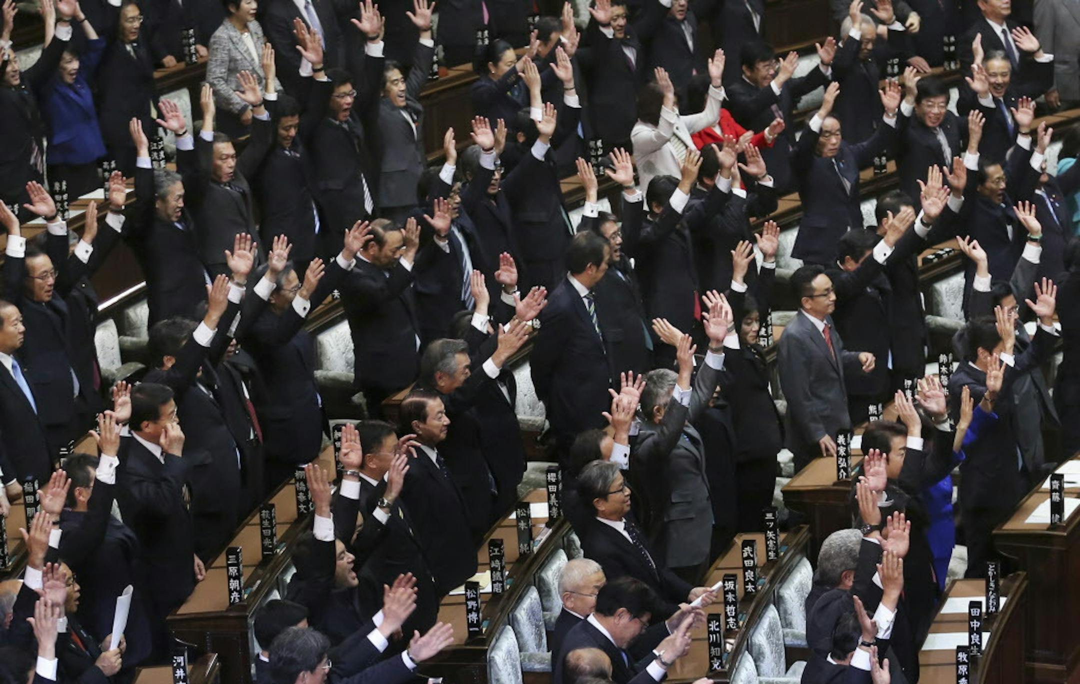 Lawmakers at the House of Representatives shout a banzai cheer after the lower house is dissolved in Tokyo, Friday, Nov. 21, 2014. Prime Minister Shinzo Abe has dissolved the lower house of Japan's parliament, paving the way for a general election next month. Friday's dissolution will lead to elections expected on Dec. 14. (AP Photo/Koji Sasahara)