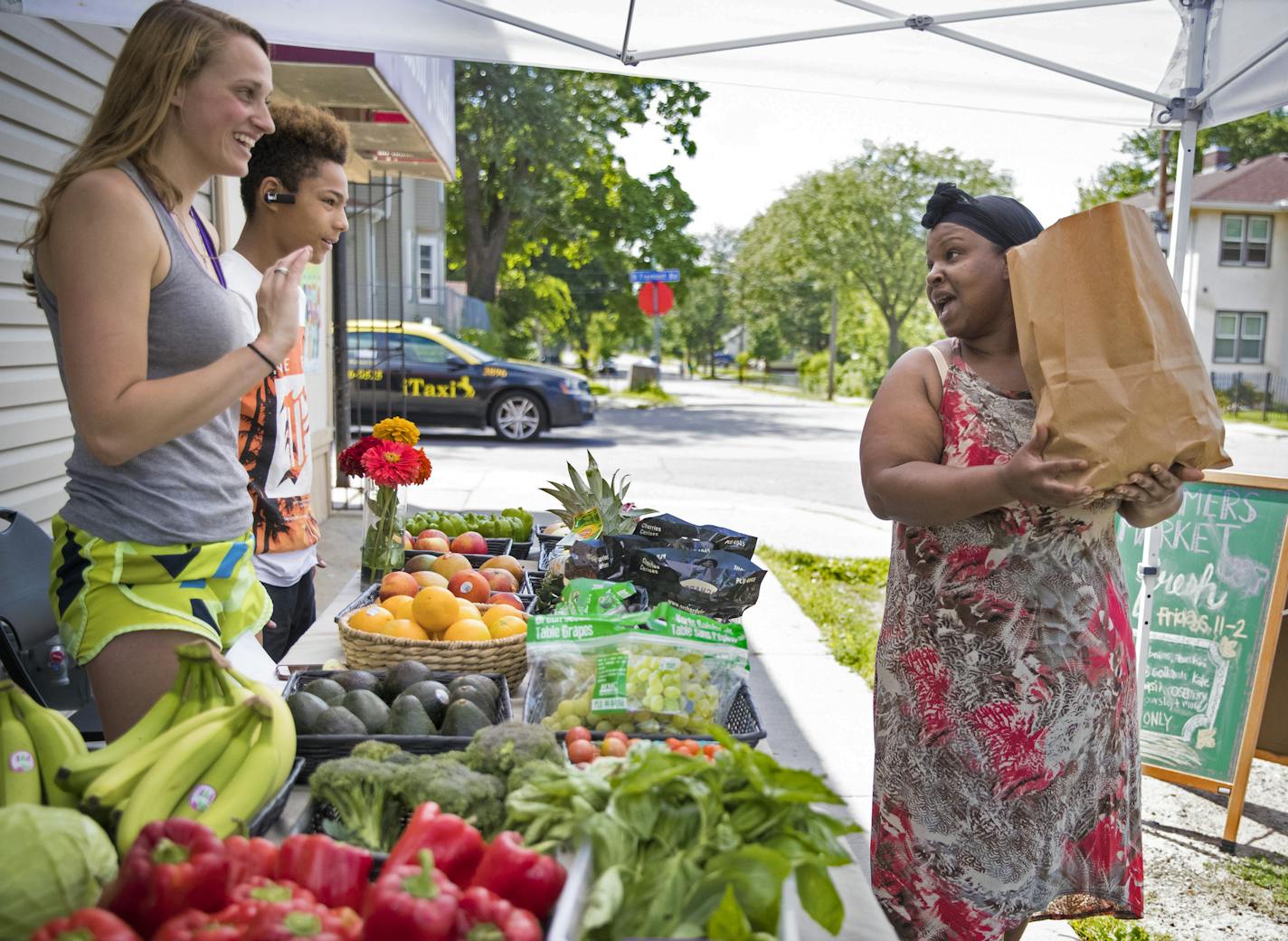 Ivie Flowers, right, chatted with Nicole Herrli, 22, a senior at St. Thomas University, and high school freshman Lunden Woodberry, 14, as she bought a bag of fruit and vegetables for under $20 at a Brightside Produce fruit stand outside Fremont Market as part of an unusual collaboration between the University of St. Thomas and corner stores in North Minneapolis on August 7, 2017 in Minneapolis, Minn. ] RENEE JONES SCHNEIDER &#xef; renee.jones@startribune.com ORG XMIT: MIN1708081317520843