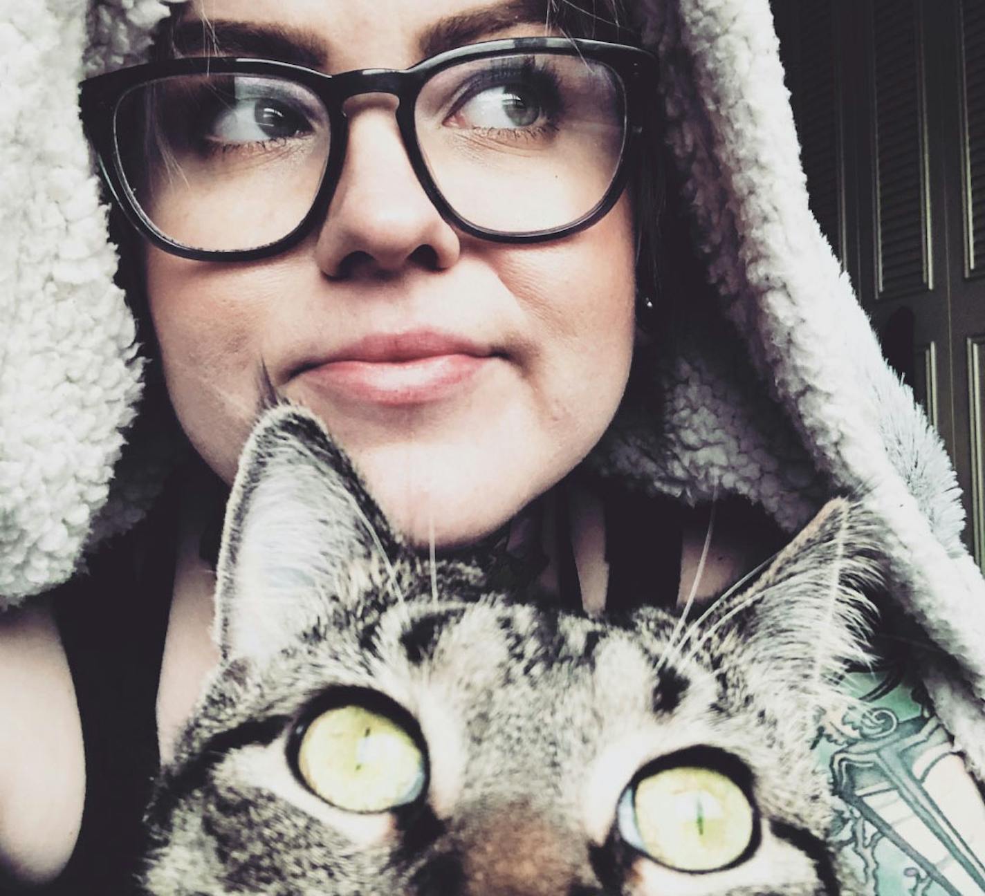 Amo Azure poses for a selfie with Foxen, their cat and "coworker," on March 30. Azure has been commissioning drawings and paintings for clients since Minnesota tattoo parlors closed last month.