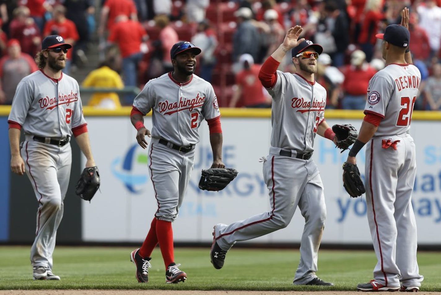 Washington Nationals players, from left, Jayson Werth, Denard Span, Bryce Harper and Ian Desmond celebrate after they defeated the Cincinnati Reds 7-6 in 11 innings in a baseball game, Saturday, April 6, 2013, in Cincinnati.