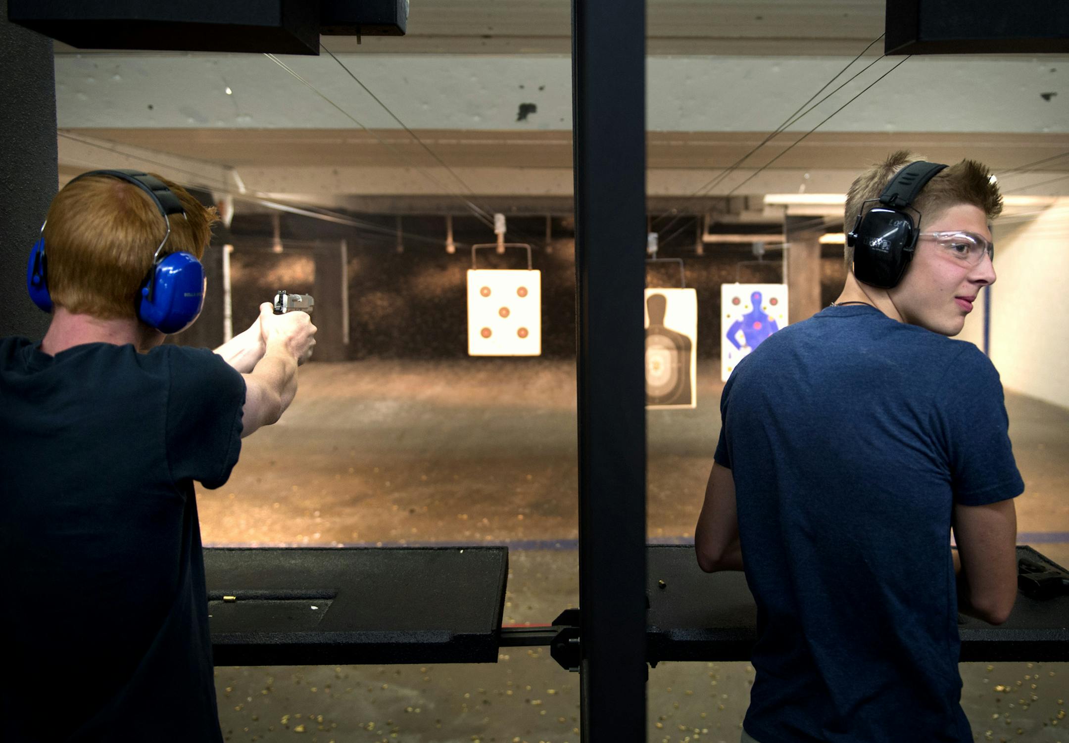 Cory nelson looked back at his father Dan as the two took turns firing at targets at Bill's Gun Shop and Range in Robbinsdale which was busy Friday afternoon. Friday, July 19, 2013 ] GLEN STUBBE * gstubbe@startribune.com