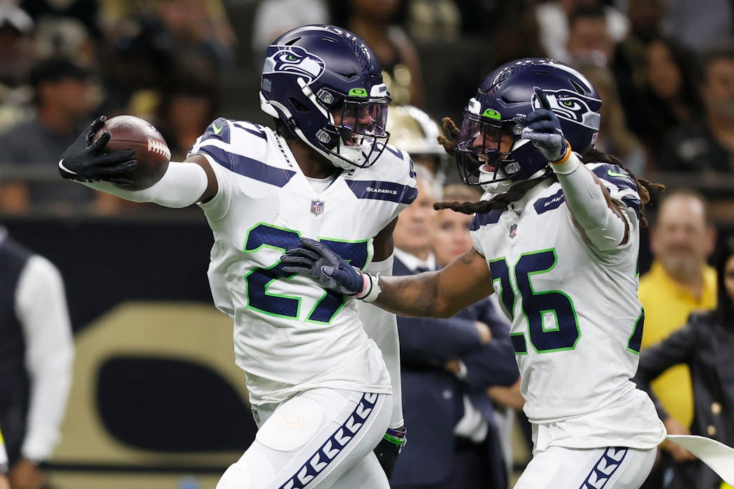 Seattle’s Tariq Woolen, left, has a league-leading four interceptions and a league-leading two fumble recoveries.