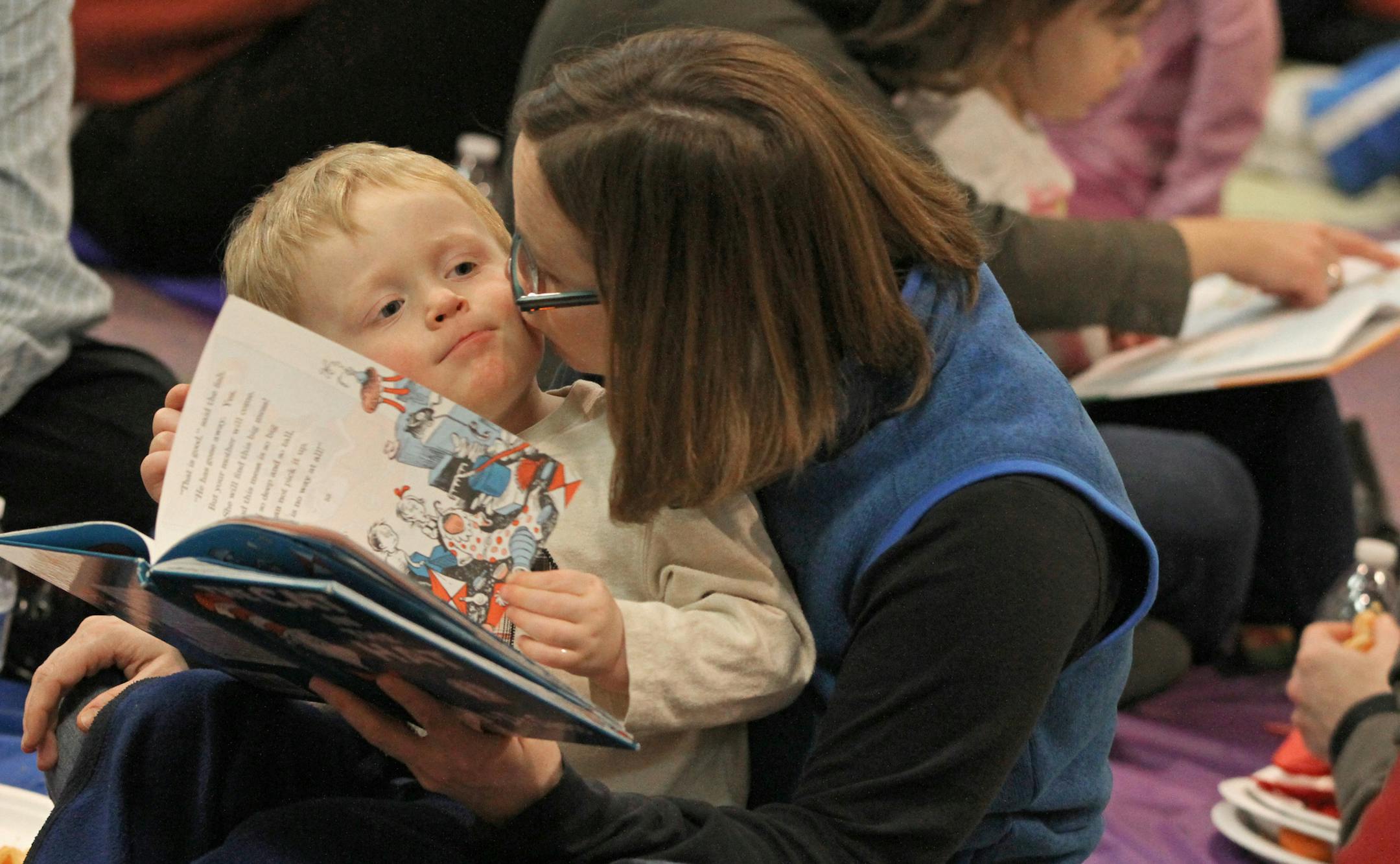 Three-year-old Sam Vanhorn of Golden Valley was the object of mother Gail’s affections as she read “The Cat in the Hat” at Kinderberry Hill in downtown Minneapolis, where Read Across America Day was celebrated with a lunchtime picnic. The children invited their parents for a day at school.