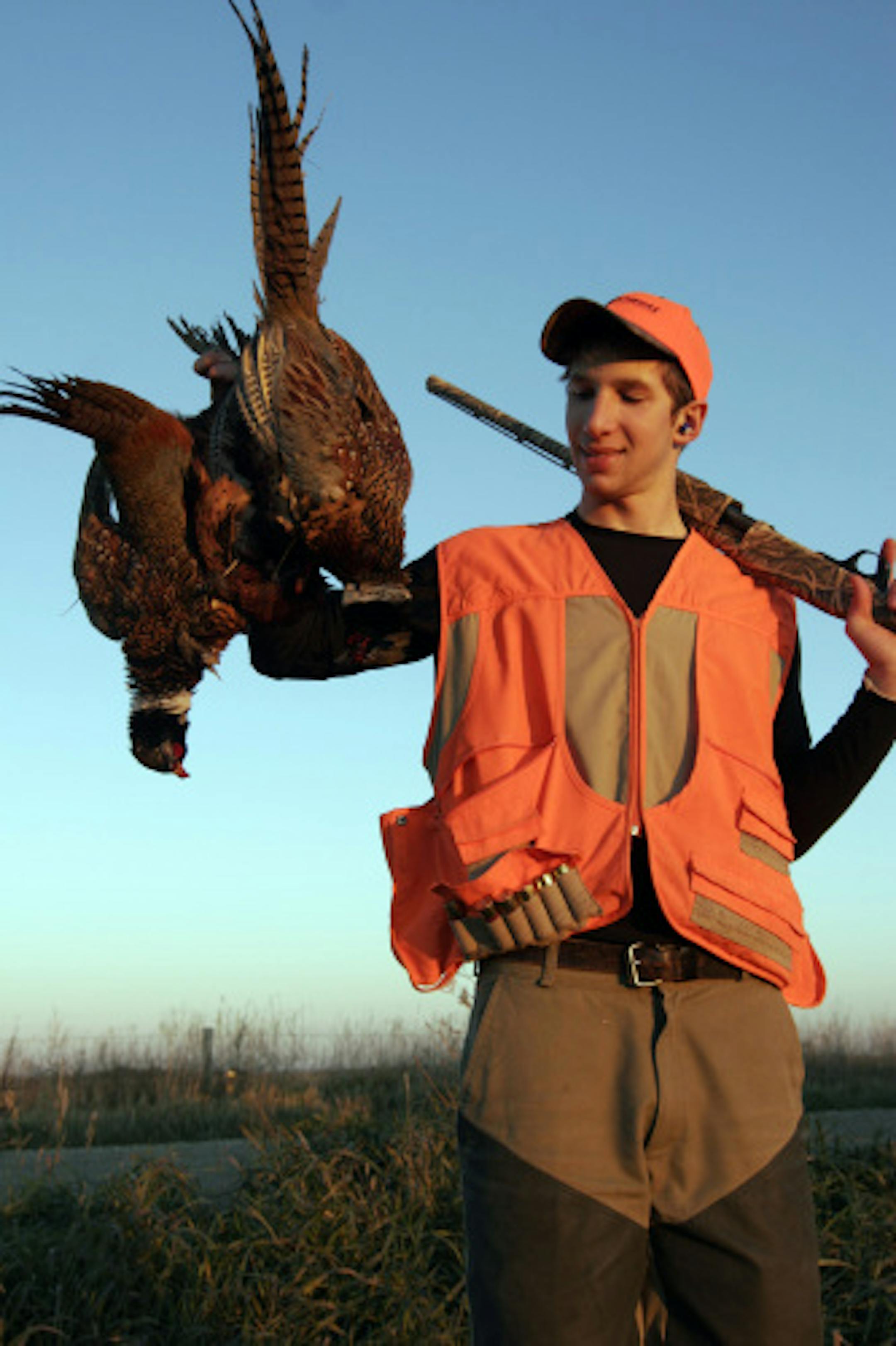 Nate Rendulich, 17, of Duluth, held a couple of roosters at the end of a South Dakota hunt. He and his partners found hunting difficult this year.