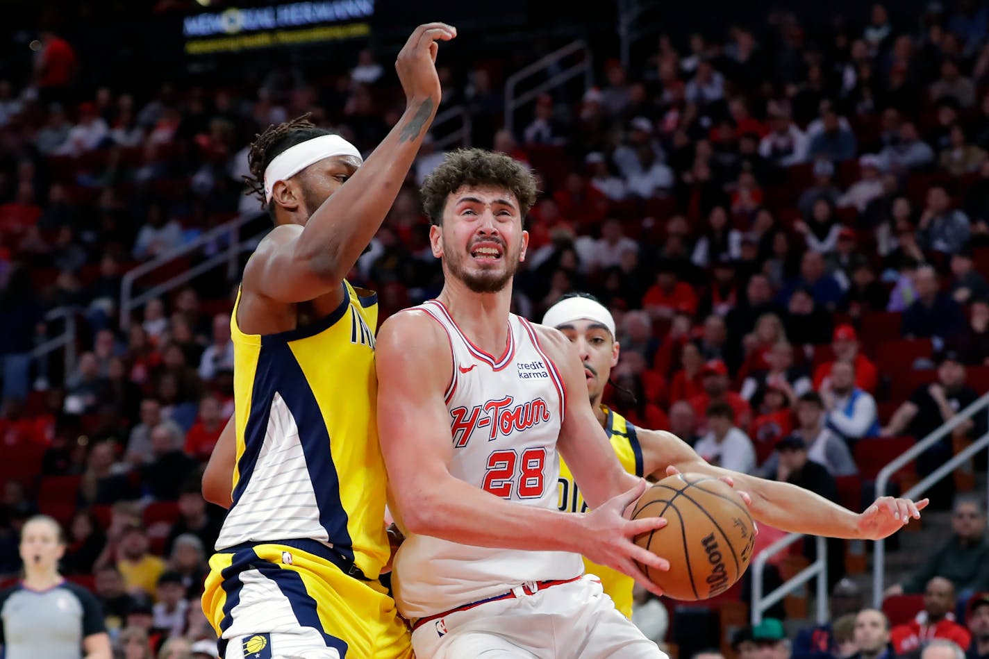 Houston Rockets center Alperen Sengun (28) drives up a shot attempt in front of Indiana Pacers forward Isaiah Jackson, left, and guard Andrew Nembhard, right, during the second half of an NBA basketball game Tuesday, Dec. 26, 2023, in Houston. (AP Photo/Michael Wyke)