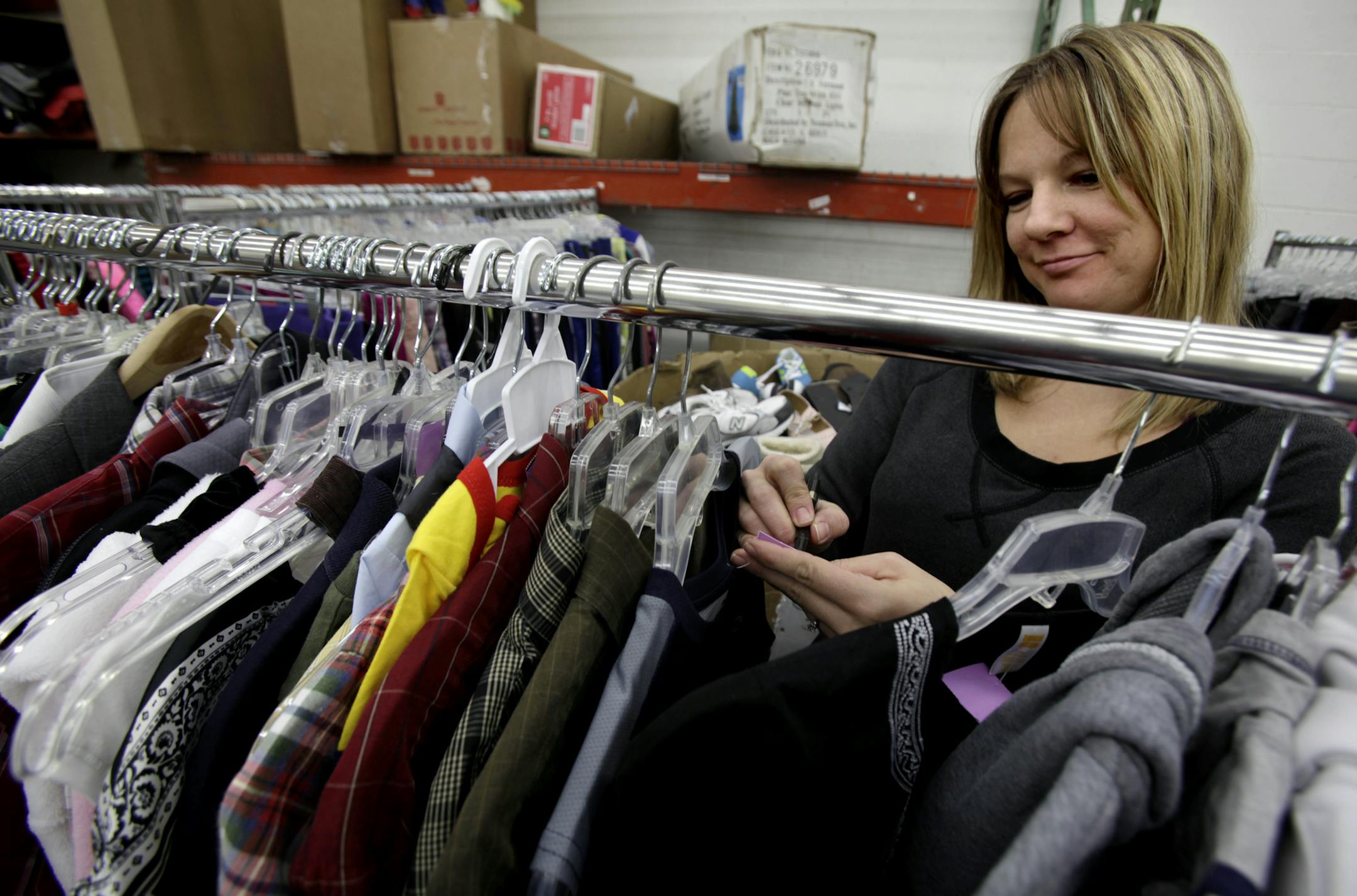 Assistant Manage Jessica Strom prices out clothing that is ready to be placed in the showroom at the Salvation Army store in Burnsville, MN on March 18, 2013. ] JOELKOYAMA‚Ä¢joel koyama@startribune.com Burnsville has 17 thrift stores and is deciding if it needs zoning or rules to regulate them. This can be shot at any time during regular store hours. Please take a photo of the outside and one inside that may say - thirft store.