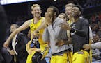 UMBC players celebrate a teammate's basket against Virginia during the second half of a first-round game in the NCAA men's college basketball tourname