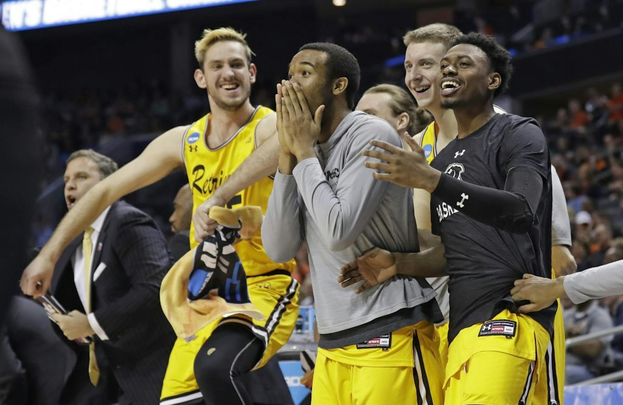 UMBC players celebrate a teammate's basket against Virginia during the second half of a first-round game in the NCAA men's college basketball tournament in Charlotte, N.C., Friday, March 16, 2018.