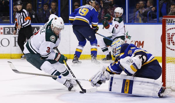 Minnesota Wild's Charlie Coyle, left, has his shot deflected by St. Louis Blues goalie Jake Allen during the first period of an NHL hockey game Saturd