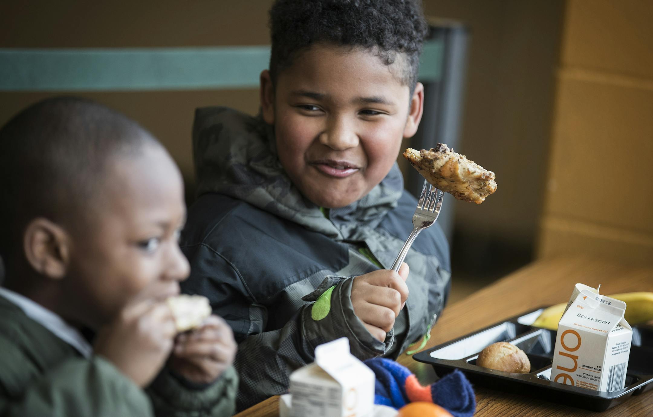 Lucy Laney first-grader Jayme Columbus' smile makes it clear what he thinks about chicken for lunch. Food service assistant Arica Burgess, above, served the chicken with potatoes and rolls for lunch on Thursday.