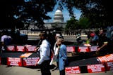 Demonstrators carry cardboard caskets in front of the U.S. Capitol in protest of President Donald Trump's tax breaks and spending cuts package on June 30 in Washington, D.C.