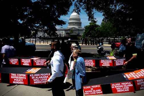Demonstrators carry cardboard caskets in front of the U.S. Capitol in protest of President Donald Trump's tax breaks and spending cuts package on June 30 in Washington, D.C.