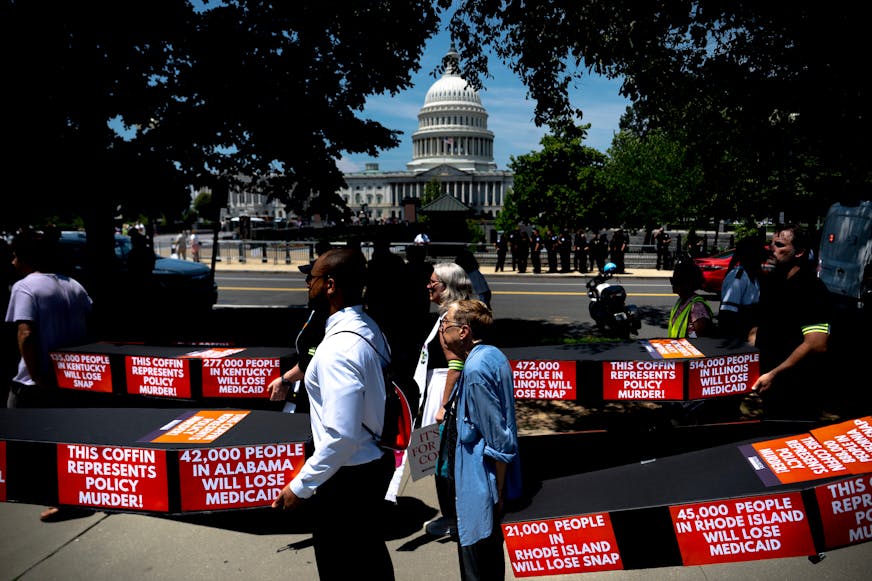 Demonstrators carry cardboard caskets in front of the U.S. Capitol in protest of President Donald Trump's tax breaks and spending cuts package on June 30 in Washington, D.C.