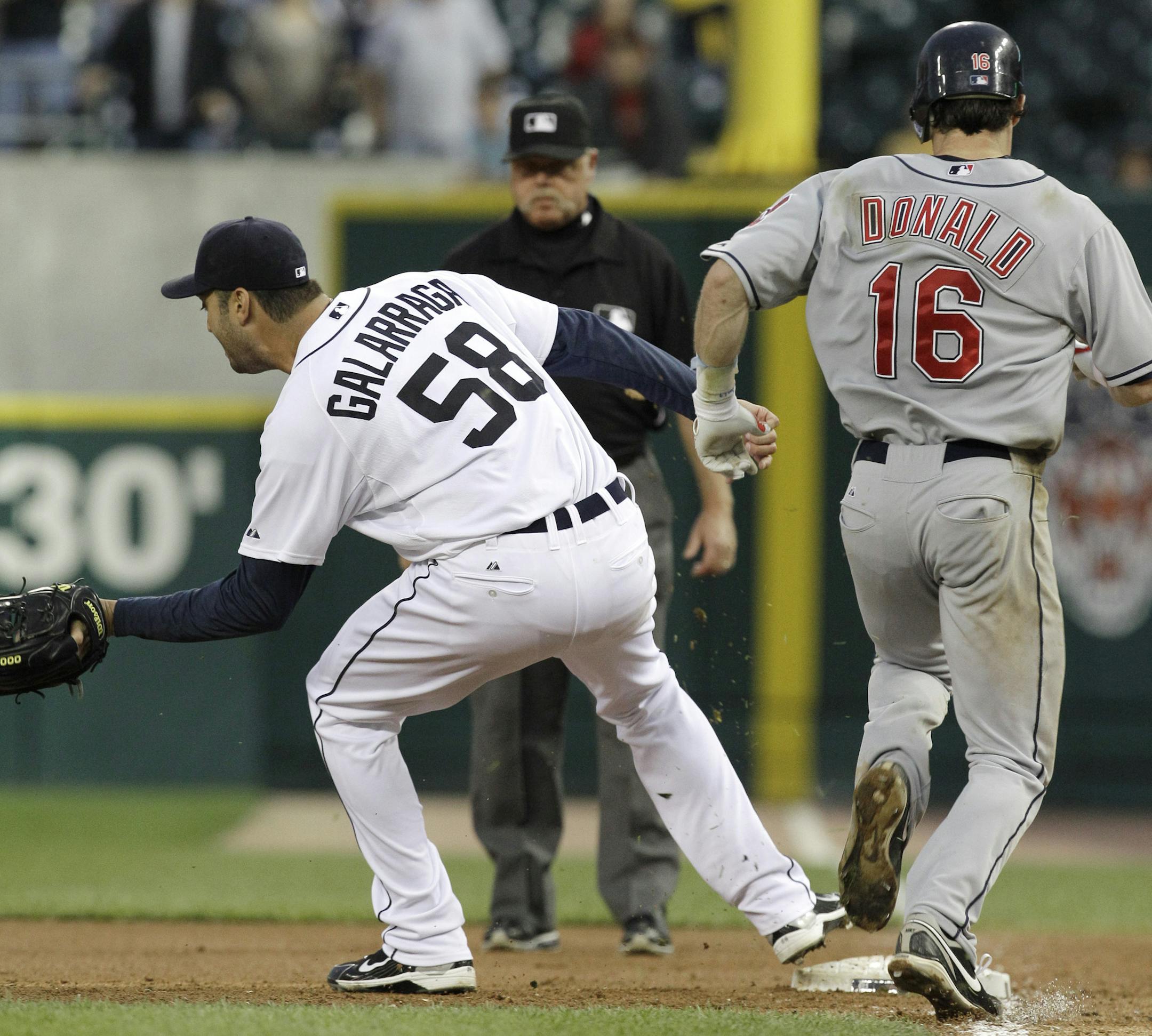 Detroit Tigers pitcher Armando Galarraga (58) covers first base as Cleveland Indians' Jason Donald, right, runs to the base and umpire Jim Joyce looks on in the ninth inning of a baseball game in Detroit Wednesday, June 2, 2010. Joyce called Donald safe and Galarraga lost his bid for a perfect game with two outs in the ninth inning on the disputed call at first base. Detroit won 3-0. (AP Photo/Paul Sancya) ORG XMIT: MIPS108