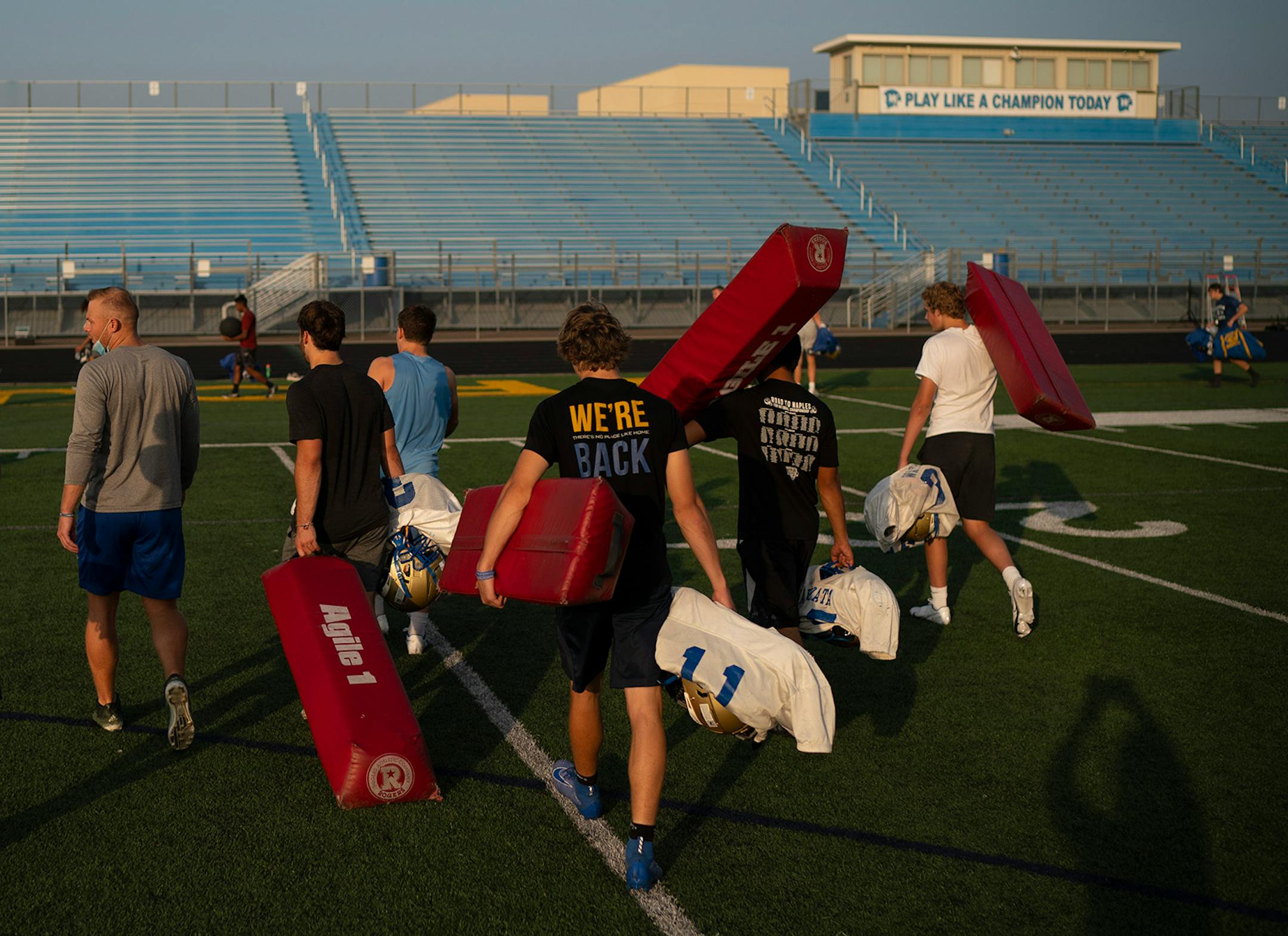 A pod of Wayzata football players carried gear as they walked off the field after a meeting after practice was over.