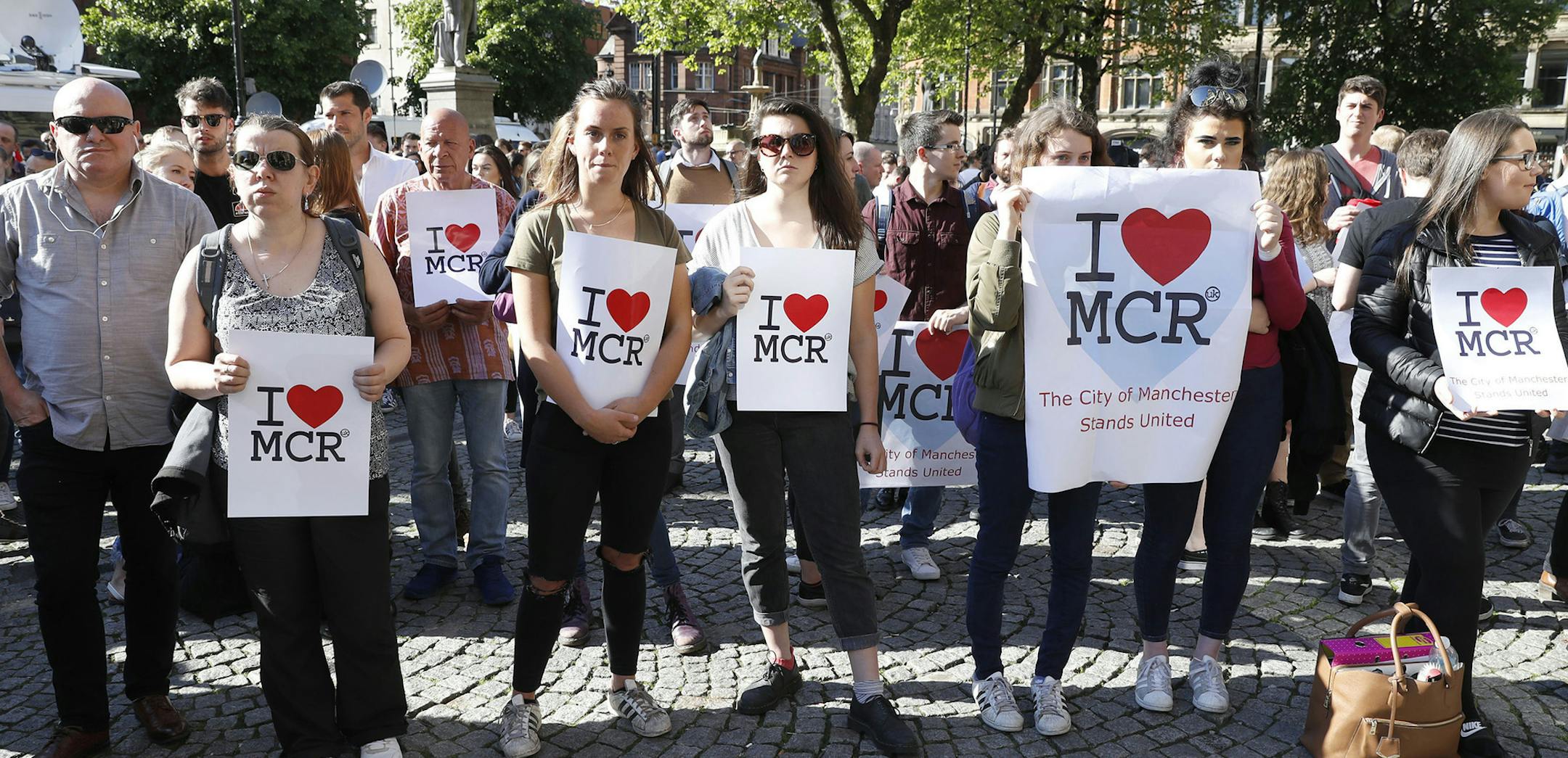 People gather ahead of a vigil in Albert Square, Manchester, England, Tuesday May 23, 2017, after a 23-year-old man was arrested in connection with Monday's Manchester concert bomb attack. The attack killed more than 20 people, including children, and injured dozens more. (Martin Rickett/PA via AP) ORG XMIT: MIN2017052312554104