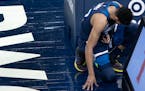 Timberwolves center Karl-Anthony Towns bends over in pain after being fouled in the first quarter of Monday’s game.