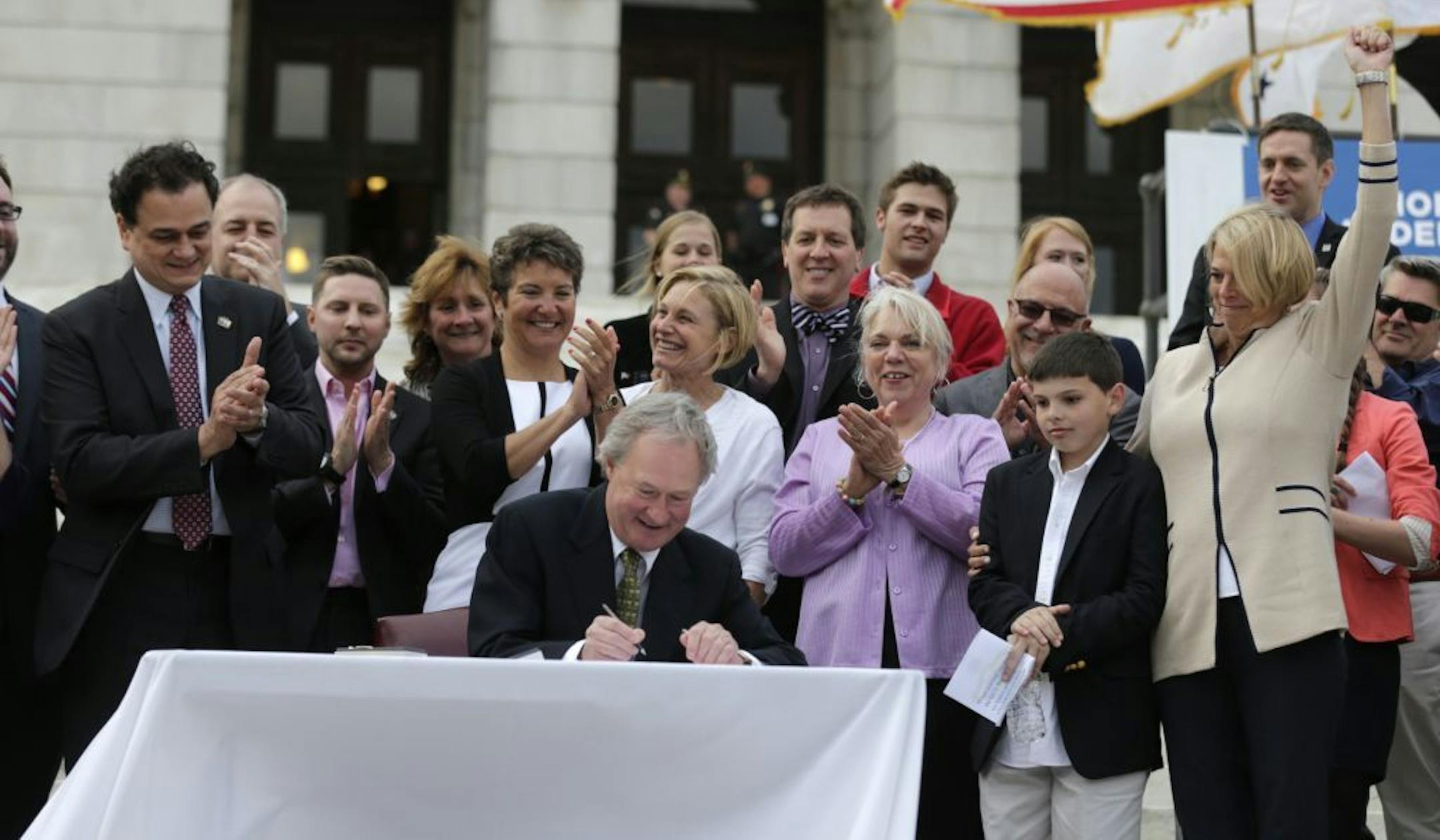Rhode Island Gov. Lincoln Chafee signs a gay marriage bill into law outside the State House in Providence, R.I., Thursday, May 2, 2013.