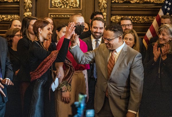 Attorney General Keith Ellison gives a high five to Katy Johnson, who was once addicted to vaping, during a press conference announcing a settlement w
