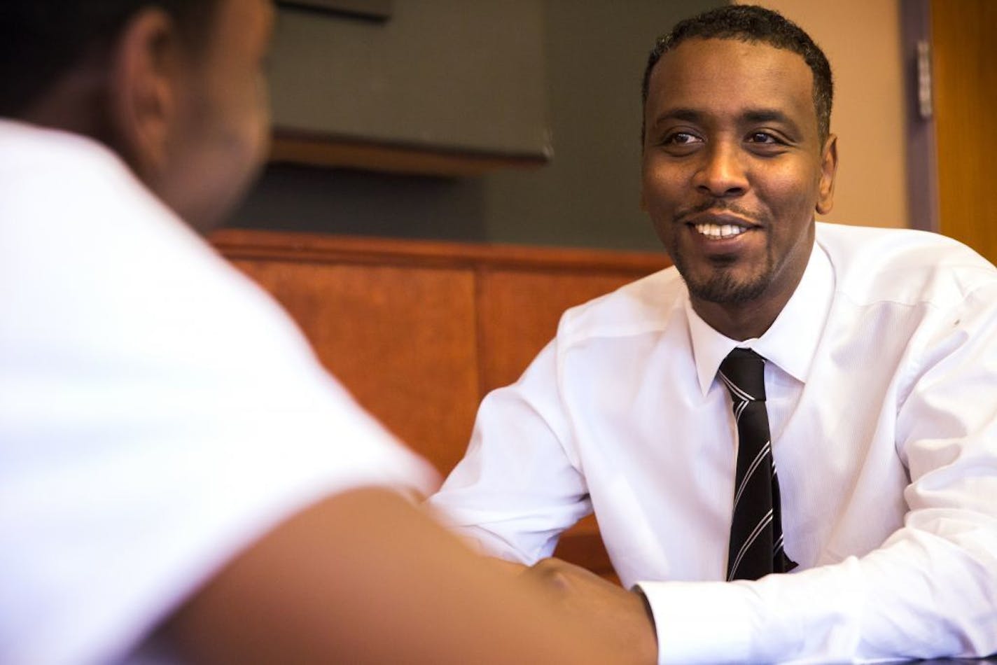 Minneapolis City Councilman Abdi Warsame, right, talks with Mubashir Jeilani, 19, at Mapps Coffee Riverside in Minneapolis on Friday, May 29, 2015.