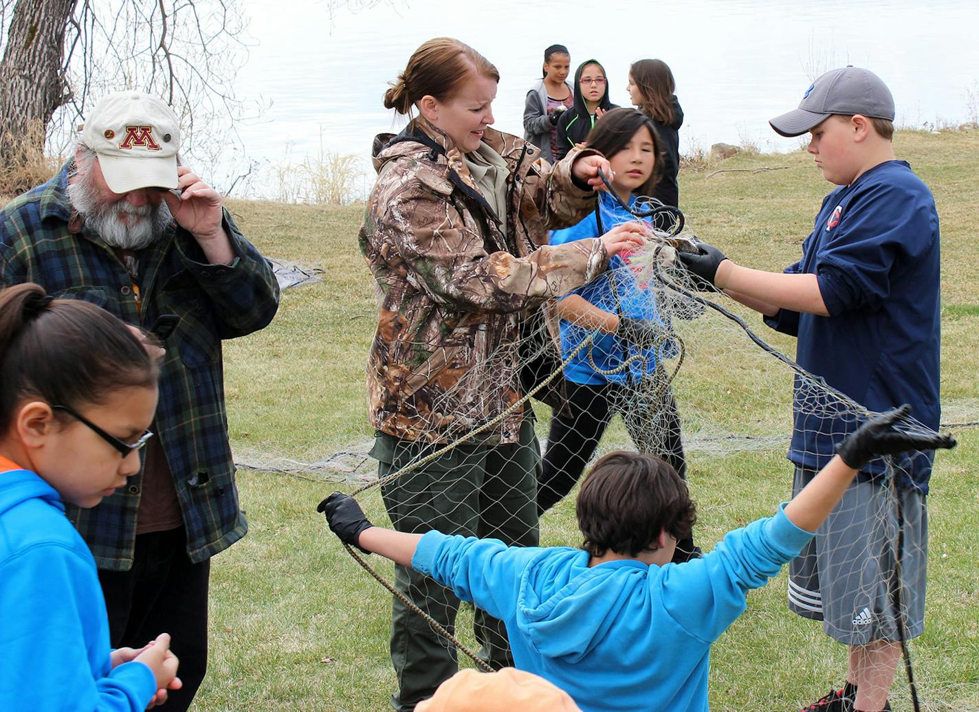 Young students who are members of the Bois Forte Band of Chippewa living near Lake Vermilion learn about fish netting as part of their education that focuses on the band's 1854 treaty with the federal government.