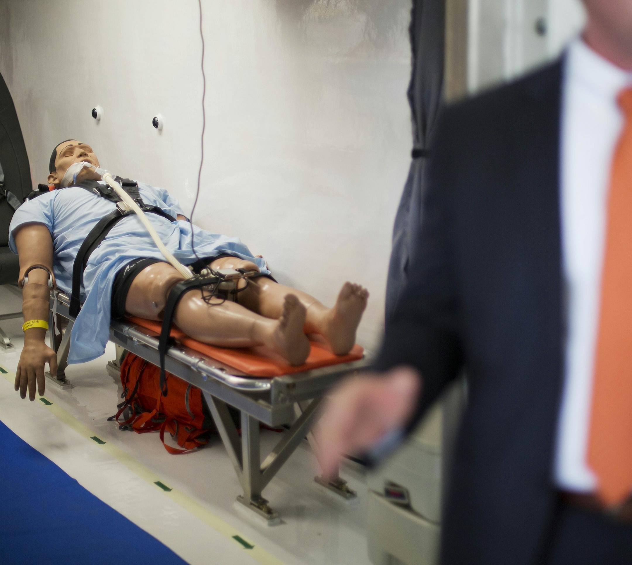 A dummy lays on a stretcher in a medevac biocontainment unit aboard a B-17 military transport plane as Dr. Will Walters, Director, Operational Medicine at U.S. Department of State, speaks to guests on a tour at Dobbins Air Force Reserve Base Tuesday, Aug. 11, 2015, in Marietta, Ga. The State Department and partners unveiled the new public-private containerized biocontainment system for highly contagious pathogens Tuesday. The first of their kind units, owned and operated by the U.S. State Depart