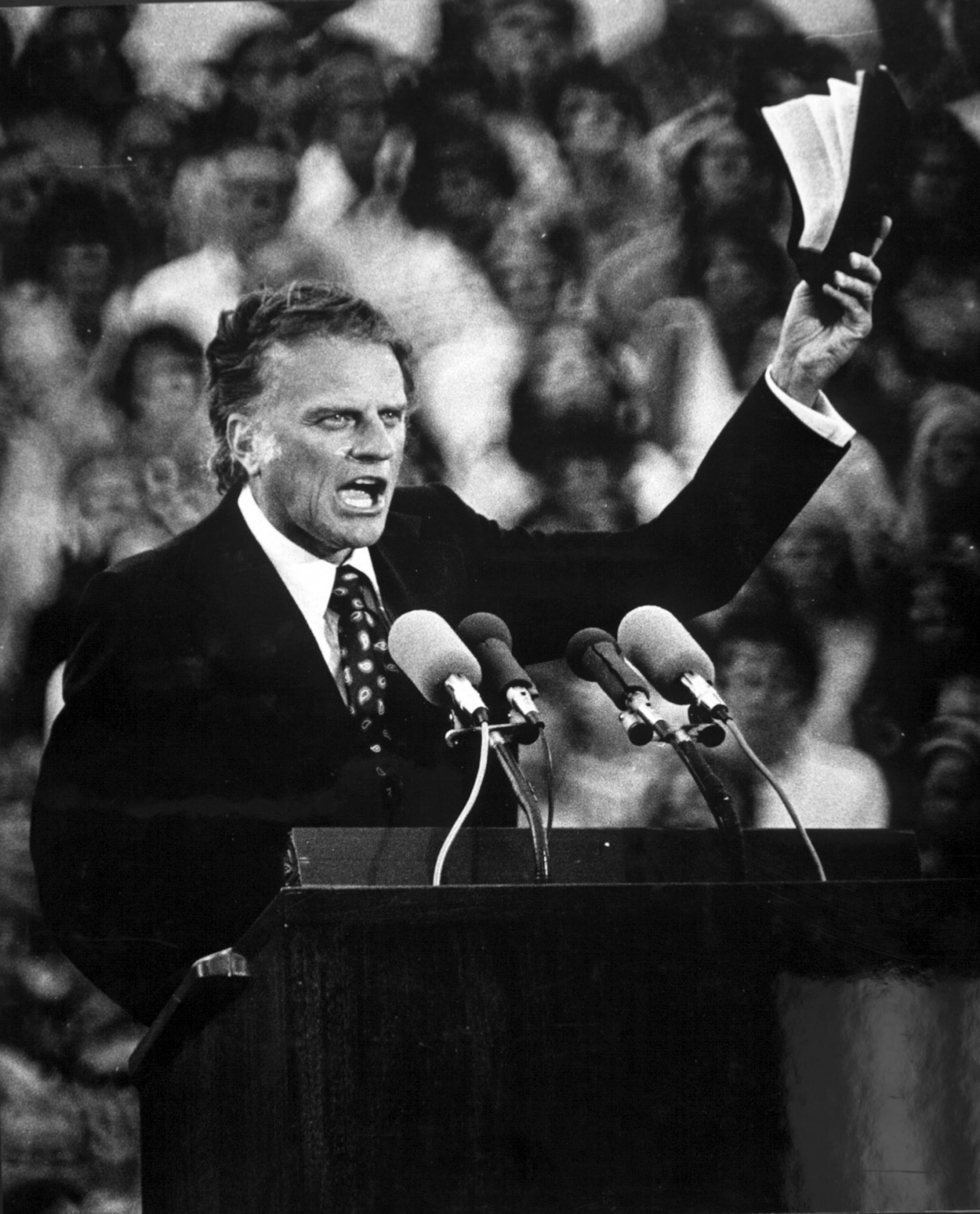 Billy Graham, waving his bible in the air, preached to a crowd of 320,000 people at crusade held at the mn state fair grandstand in July 1973