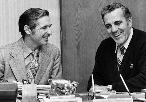 Dan Devine, left, former head coach of the Green Bay Packers, and Ara Parseghian, retiring head coach of Notre Dame University, go over transitional matters in Parseghian's office at South Bend, Dec. 17, 1974. Devine will succeed Parseghian at Notre Dame. (AP Photo/Charles Knoblock)