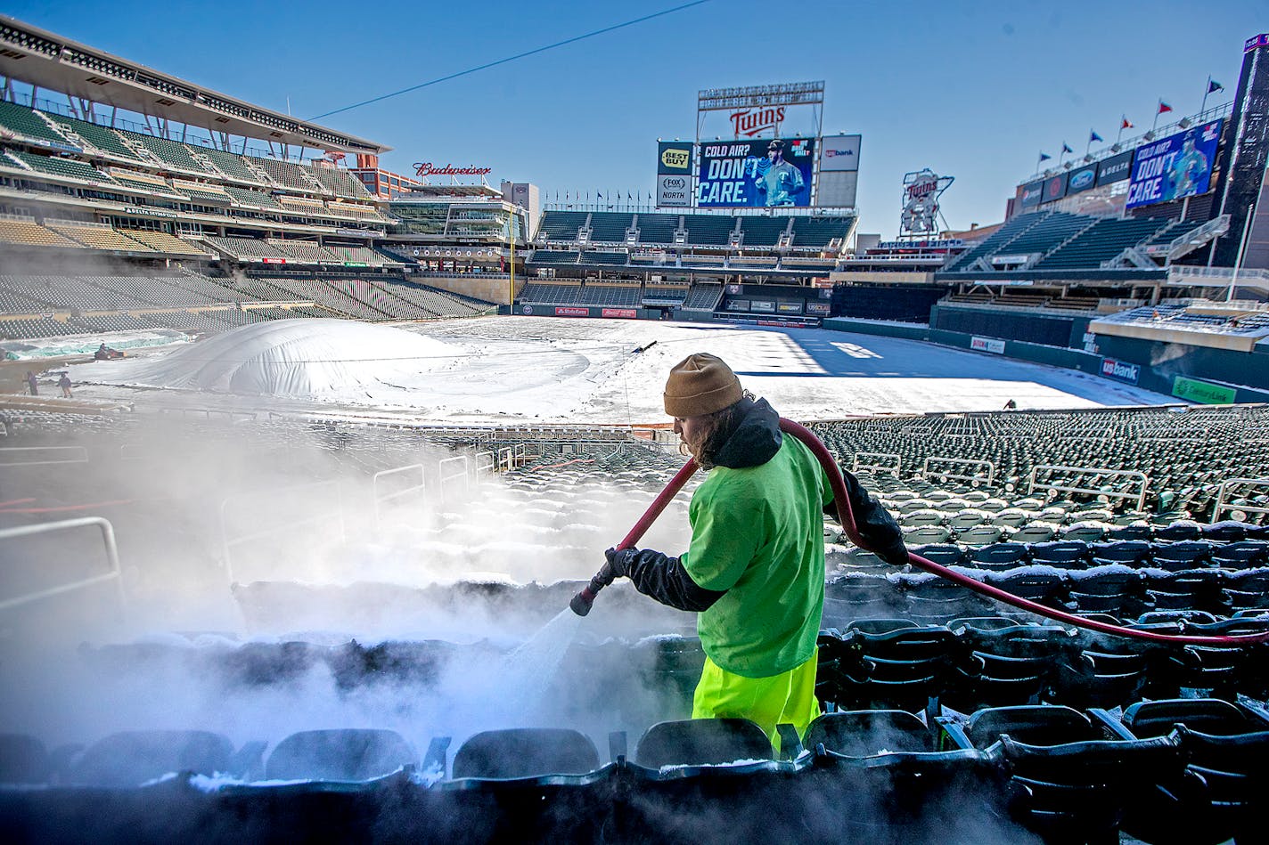 In advance of Thursday's home opener Andrew Hagl, of Columbia Heights, melts snow with hot water on Target Field seats. Twins staff used many strategies to clear snow from a storm that dumped up to 6 inches of snow across the Twin Cities beginning Monday afternoon.