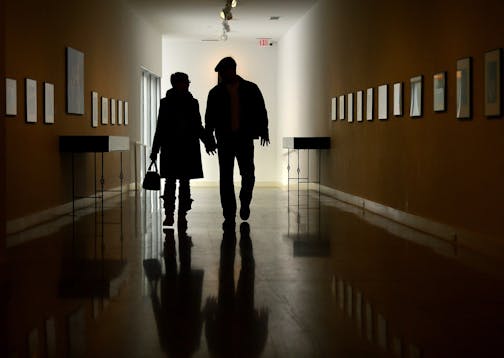 FILE - In this Jan. 7, 2014, file photo, a couple walks down the Bacon Gallery at the Erie Art Museum in Erie, Pa. More and more retirement savers have their entire 401(k) account in just a single mutual fund, and investment advisers are fine with it. (Jarid A. Barringer/Erie Times-News via AP, File)