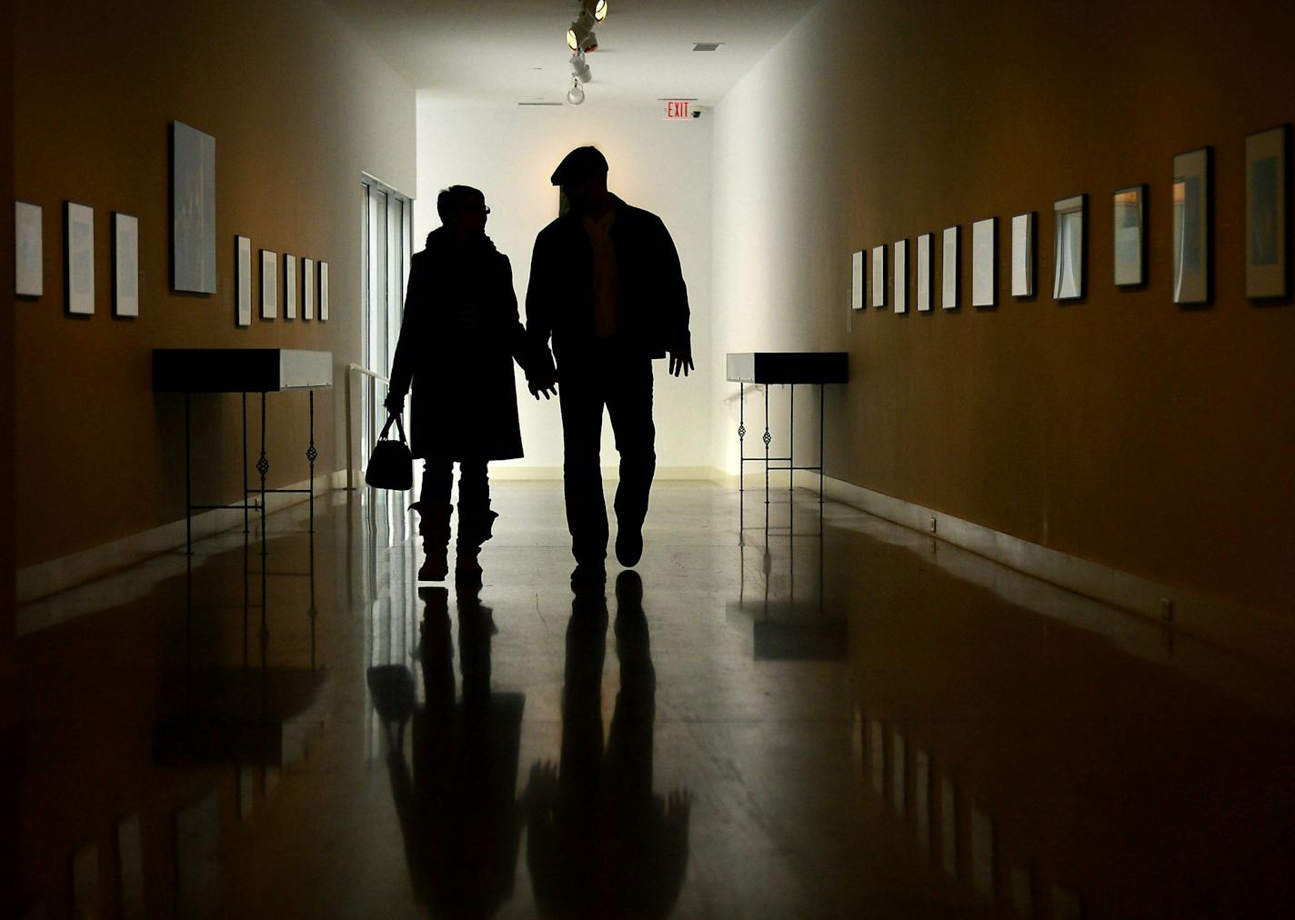 FILE - In this Jan. 7, 2014, file photo, a couple walks down the Bacon Gallery at the Erie Art Museum in Erie, Pa. More and more retirement savers have their entire 401(k) account in just a single mutual fund, and investment advisers are fine with it. (Jarid A. Barringer/Erie Times-News via AP, File)