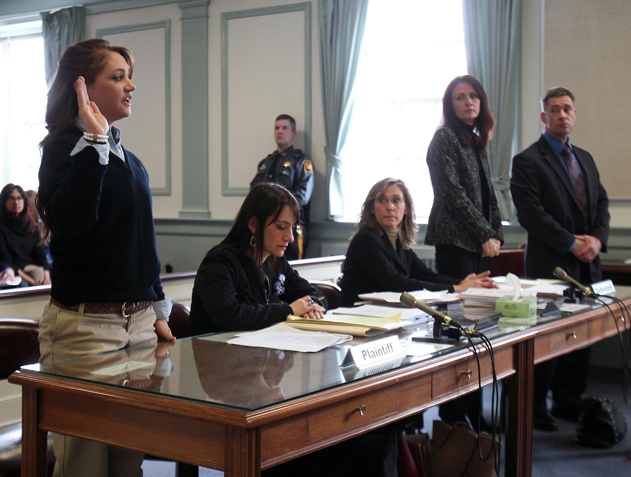 High school student Rachel Canning, 18, left, takes the oath in court as her parents, Elizabeth and Sean, look on in Morris County Superior Court in Morristown, N.J., Tuesday, March 4, 2014. Rachel Canning is suing her parents for financial support and college tuition after she claims they threw her out of the home. (AP Photo/Daily Record, Bob Karp, Pool) ORG XMIT: MIN2014030612534741