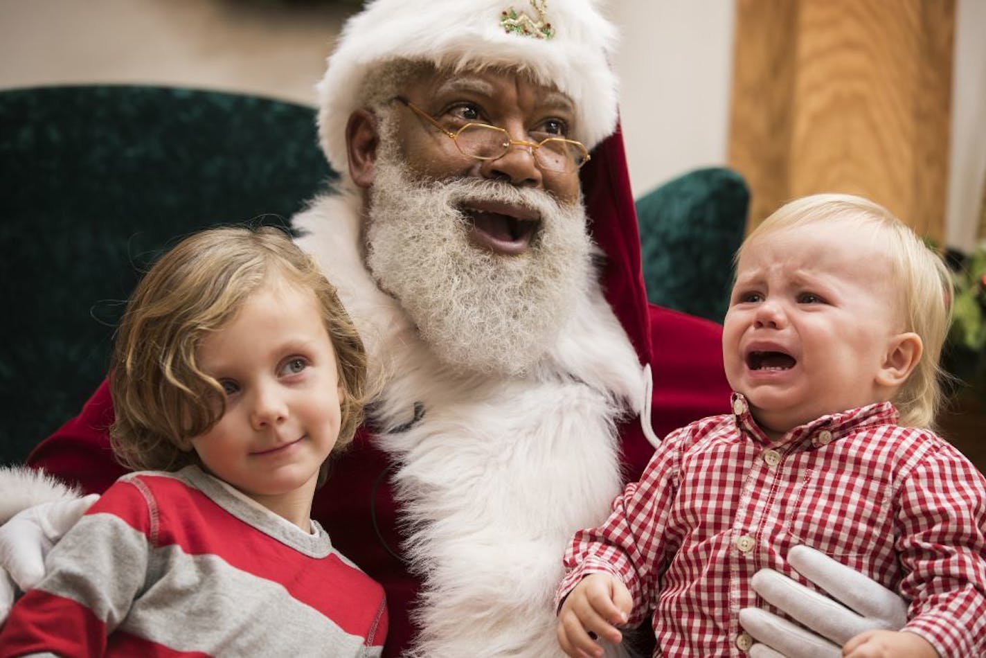 Santa Larry Jefferson smiles with Auden Good, 4, and his one-year-old brother Ezra of Ramsey during photos at the Santa Experience at Mall of America.