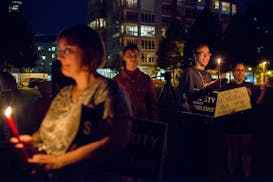 People gather for a candlelight vigil in solidarity with Charlottesville counter protesters at Gold Medal Park, on Saturday night.