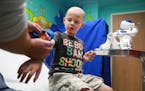 Tommy Boegler, 4, of Tamarac, Fla. with MEDi at his side during a visit to Broward Health. The hospital is one of eight hospitals nationwide using a c