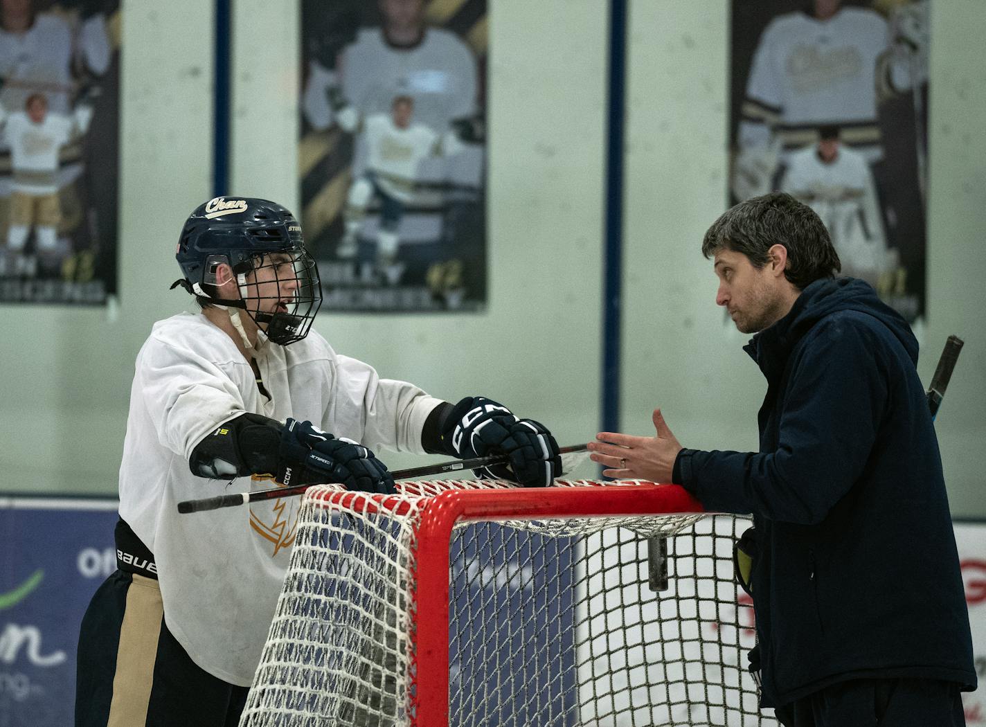 Jake Risch (8) talks to head coach Sean Bloomfield as they put way the goals at the end of practice in Victoria, Minn., on Tuesday, Jan. 9, 2024. This is a story on Chanhassen boys hockey and what it takes to be one of the elite teams in the state. ] RICHARD TSONG-TAATARII • richard.tsong-taatarii @startribune.com