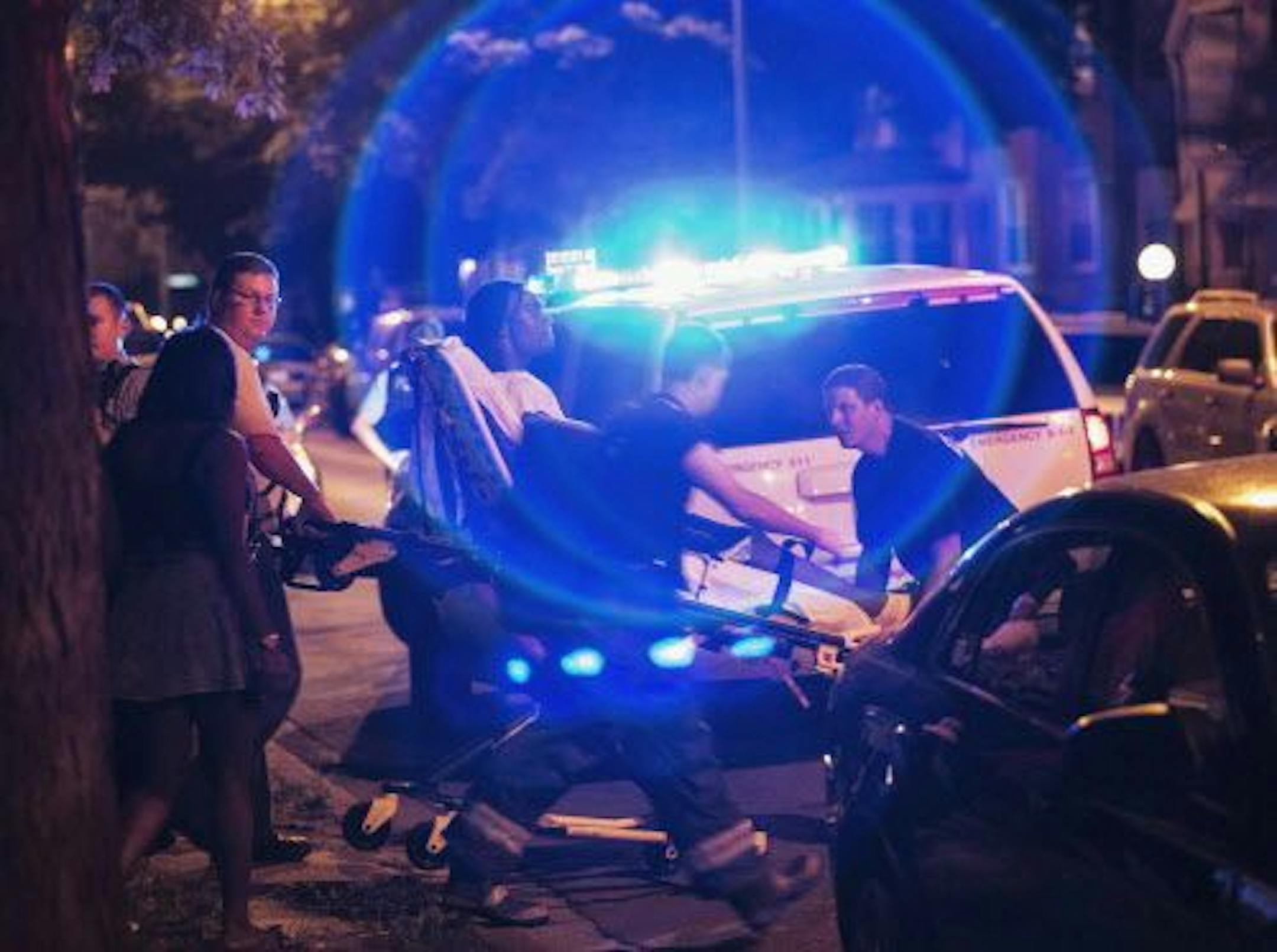 In this Sunday, July 6, 2014 photo, a man is wheeled on a stretcher after being shot in the leg on Chicago's South Side. The Fourth of July weekend was a bloody one in Chicago, where at least nine people were shot to death and at least 60 others were wounded. (AP Photo/Sun-Times Media, Alex Wroblewski) MANDATORY CREDIT, MAGS OUT, NO SALES