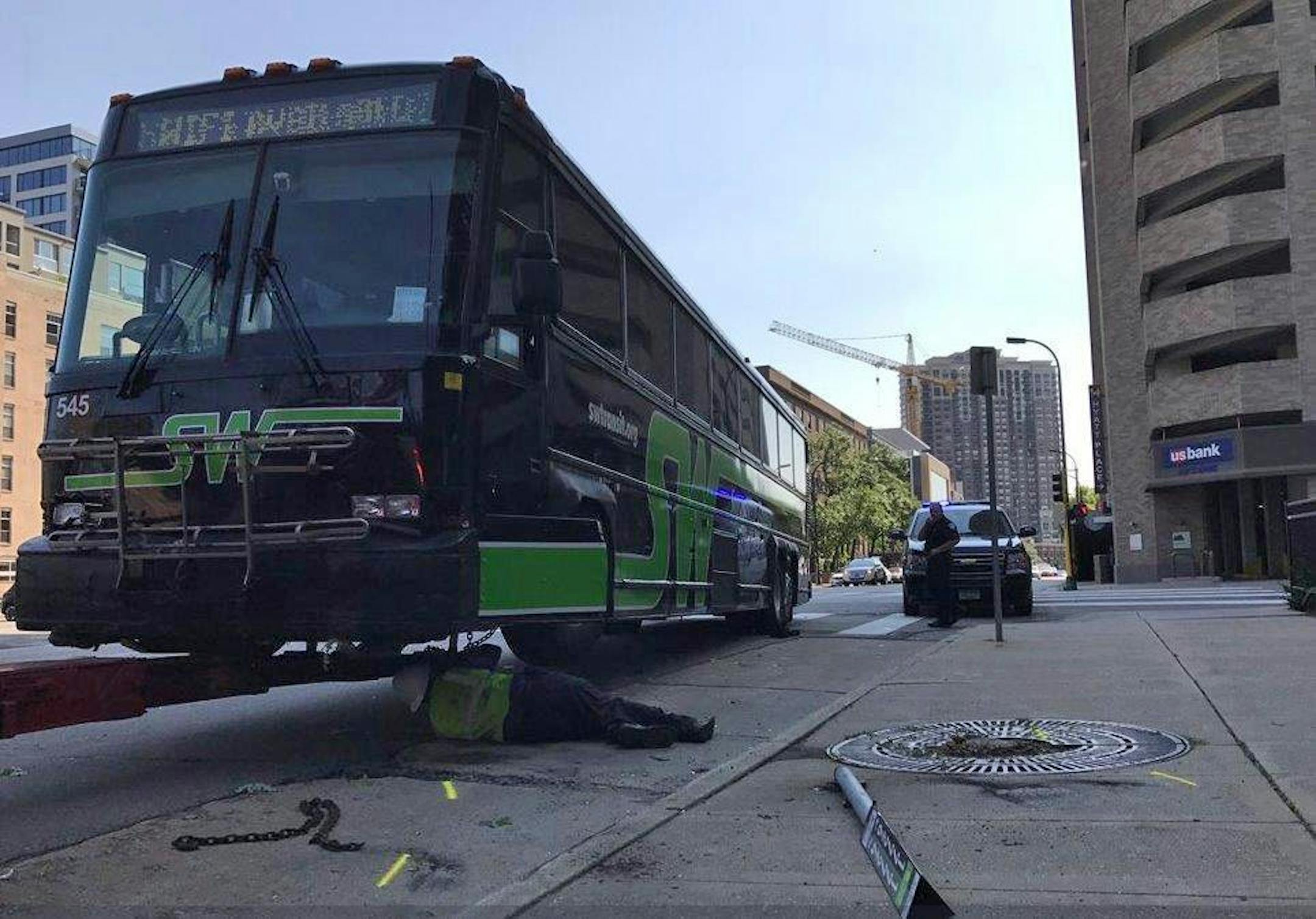 Photo by Miguel Otarola / Star Tribune 9/2/17 A tow truck driver attached a chain to a bus that was damaged in a bus-car collision Saturday in downtown Minneapolis.