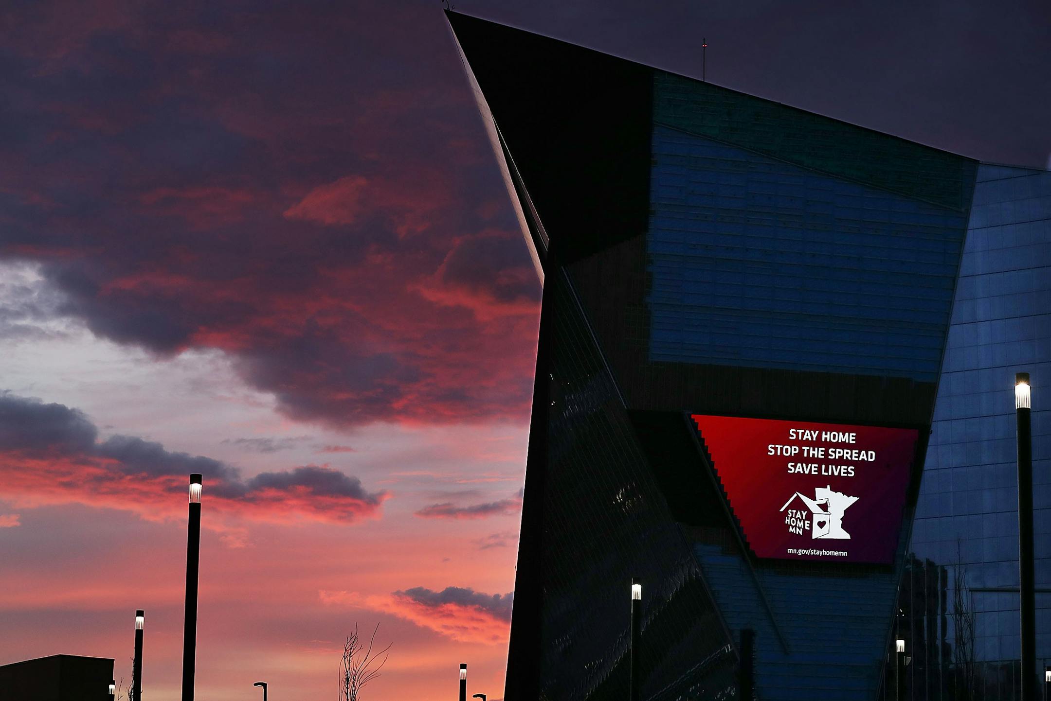 A beautiful sunrise could be seen behind the US Bank Stadium Wednesday, April 8, 2020, in Minneapolis, where video messaging on the stadium urged Minnesota residents to heed warnings and stay home in wake of the Coronavirus pandemic.